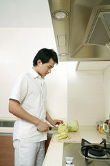 Fototapeta na wymiar Man cutting vegetables in the kitchen