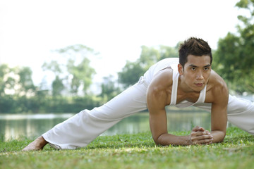 Man practising yoga in the park