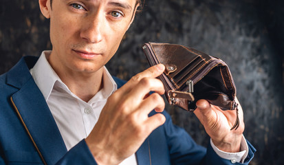 Man is holding an open empty leather wallet purse. Economic crisis and business bankruptcy in the...
