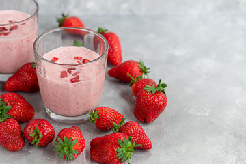 Strawberry and yogurt smoothies on a gray background. Decorated with elderberry flowers and strawberries. Healthy nutrition, diet.