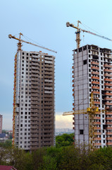 Fototapeta na wymiar cranes and the construction of new houses in a big city on a warm day, Kiev, Ukraine