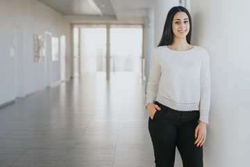 Smiling young woman going to a job interview in a corporation