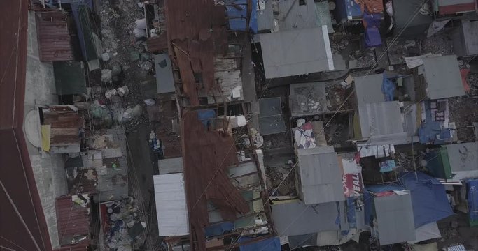 Ungraded, Ascending rotating bird's eye view aerial flight over burned house revealing squatter area. Drone, 4K. 