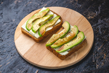 Healthy vegetarian sandwiches with sliced avocado and tofu cheese. Modern and simple Breakfast