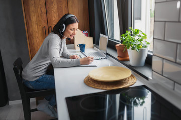 Young Woman Sitting in front of Laptop Computer at Home. Distance learning. Online language courses. Working remotely © lordn