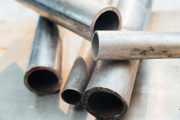 Stainless steel scrap metal, stainless steel pipes on the background of a stainless steel sheet. Close-up. Macro.