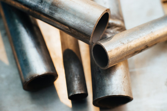 Stainless Steel Scrap Metal, Stainless Steel Pipes On The Background Of A Stainless Steel Sheet. Close-up. Macro.