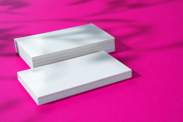 Advertising mock-up. White blank businesscards on bright pink background
