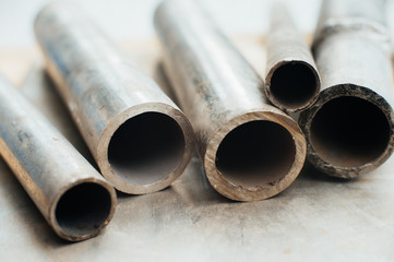 Stainless steel scrap metal, stainless steel pipes on the background of a stainless steel sheet....