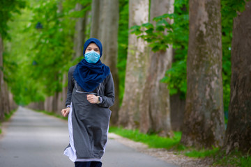 Young muslim runner wearing face mask in nature