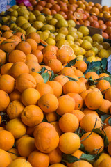 Fresh organic juicy orange fruits, lemons, mandarins lying on counter on street food market, farmers fair, greengrocer's shop. Colorful food, healthy vegan vegetarian lifestyle concept.