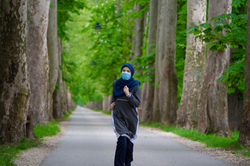 Young muslim runner wearing face mask in nature
