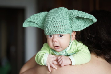 Newborn baby in the crotchet green cap with ears looks like one famous star master baby character's cosplay.