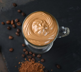Glass cup with Dalgona frothy coffee trend korean drink latte espresso with coffee foam