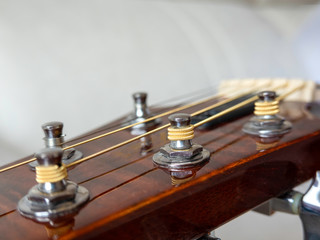 Typical acoustic guitar.Detail of string tensioning. Selective focus