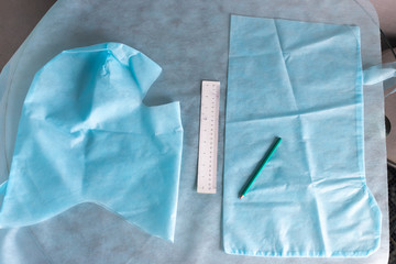 pattern of medical protective clothing, tailoring of shoe covers and helmet from medical blue fabric used in coronavirus