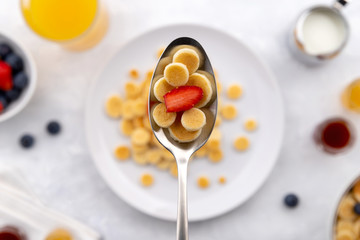 Tiny mini pancake cereal. Home made breakfast with raspberries, blueberries, jam and juice on gray background