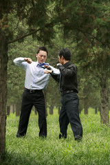 Businessmen pulling another man's tie
