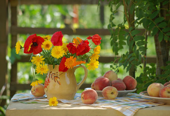Still life with ripe peaches and a bright red-orange bunch of poppies and calendula flowers