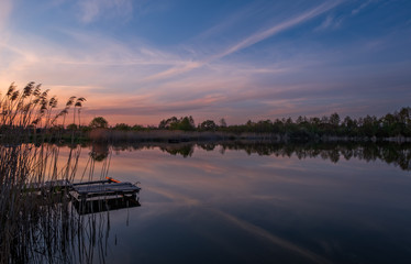 Sunset evening view on Sukhovilske Lake and forest in Sukhovolia, Rudno. Lviv district, Ukraine. May 2020