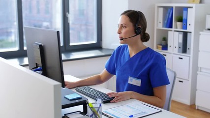 medicine, technology and healthcare concept - female doctor or nurse with headset and computer working at hospital - Powered by Adobe