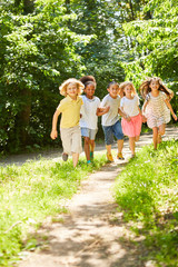 Group of kids running together over meadow