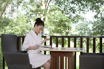 Woman flipping a book while holding a cup of tea