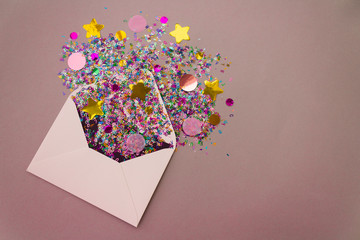 Opened white envelope with multicolored sparkle glitter confetti letters on pastel lilac background. Festive greeting concept. Flat lay style. Top view. Copy text