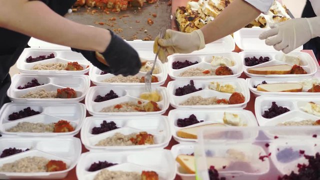 close-up, Volunteers pack free hot meals in lunchboxes, for poor people during lock down of covid19. food delivery. Charity project, donating aid,