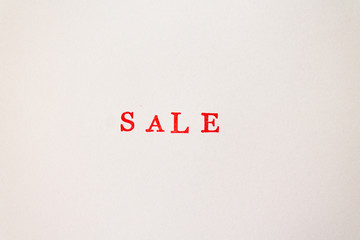 The red word sale stamped on a white paper. Price reduction and promotion in trade and services concept photo.