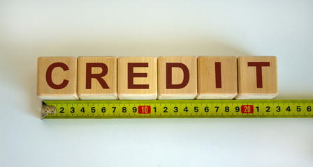 'Credit' word on cubes arranged behind the ruler on beautiful white background. Concept.