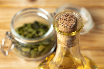 Olive oil bottle on wooden table, close up.
