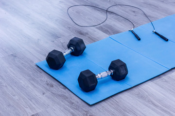 black dumbbells on blue mat