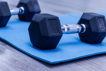 black dumbbells on blue mat