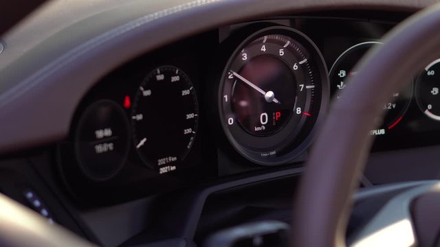 Large speedometer Needle rises up. They started the sports car. Transmission panel. The instrument panel and the technical parameters of the machine. Revs and picks up speed. Resets the speed. Brakes.