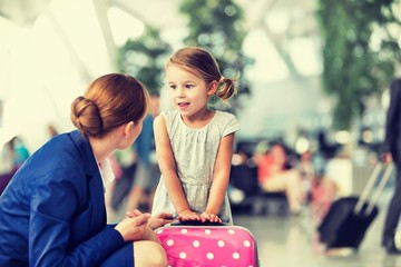 Young attractive airport staff talking to cute little girl in airport