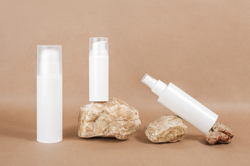 Set of face care cosmetic. White blank cosmetics bottles, tube and rocks on beige background. Natural Organic Spa Cosmetic Beauty Concept. Front view Mock up