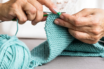 Close-up of hands knitting using circular needles.