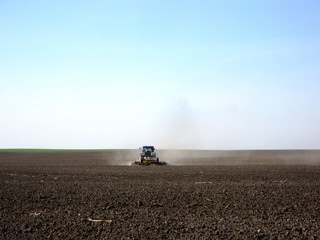 Plowed field by tractor in brown soil on open countryside nature