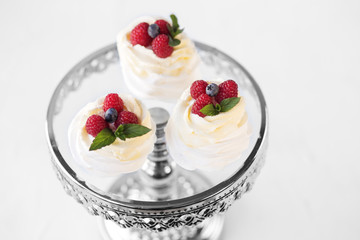 Meringue dessert with berries. Beautiful stand. The concept of desserts, bakery and holiday.