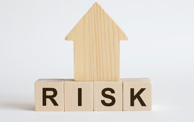 RISK. Solution word written on wood block.