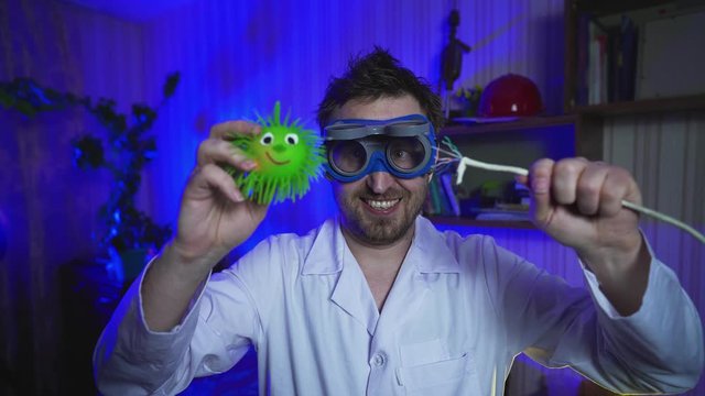Doctor coronavirus. Crazy doctor is shocking the virus. Treatment Covid-19. Funny scientist conducts tests in the laboratory. Electric shock. Hairy Computer nerd with big glasses and a white coat. 