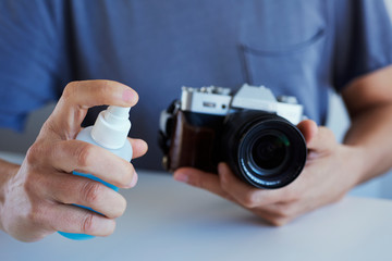 Fototapeta premium man disinfecting his camera