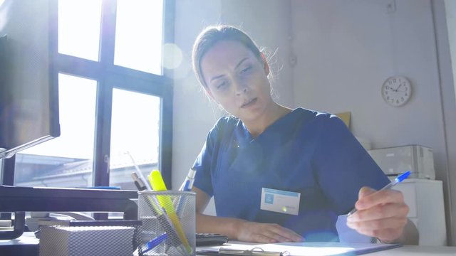 medicine, technology and healthcare concept - female doctor or nurse with computer and medical report working at hospital