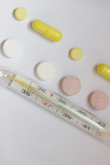 tablets and thermometer on a white background