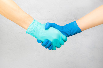 doctors shaking hands with medical gloves