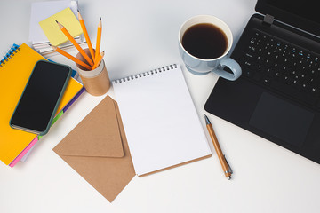 Top view on modern creative enterpreneur workspace. Blue cup of coffee, yellow pencils in reusable paper tube and empty notebook with copy space on the table. Home office, distance learning concept