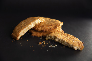 Biscuits with crumbs everywhere, located on a black background in a small home studio.