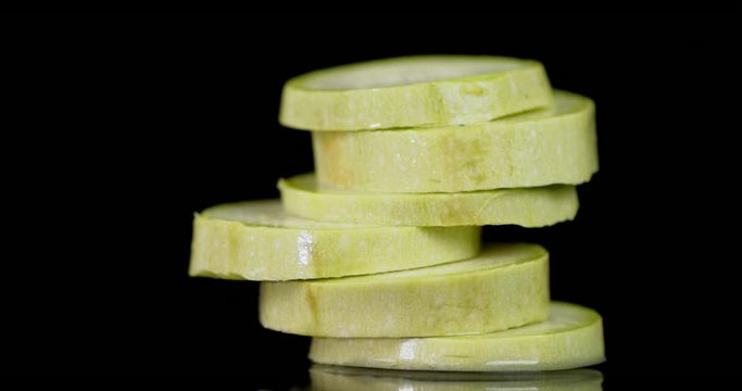 A bunch of sliced zucchini rotates slowly.