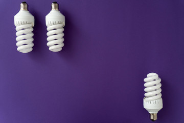 Two halogen white lamps on the top of violet background and one halogen lamp on the bottom, copy...